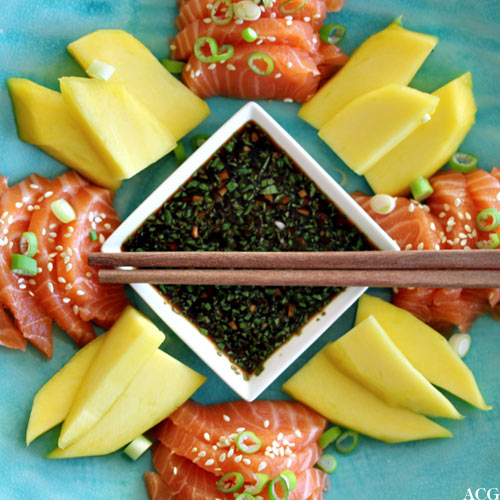 Bilde av sashimi, mango og ponzusaus ovenfra